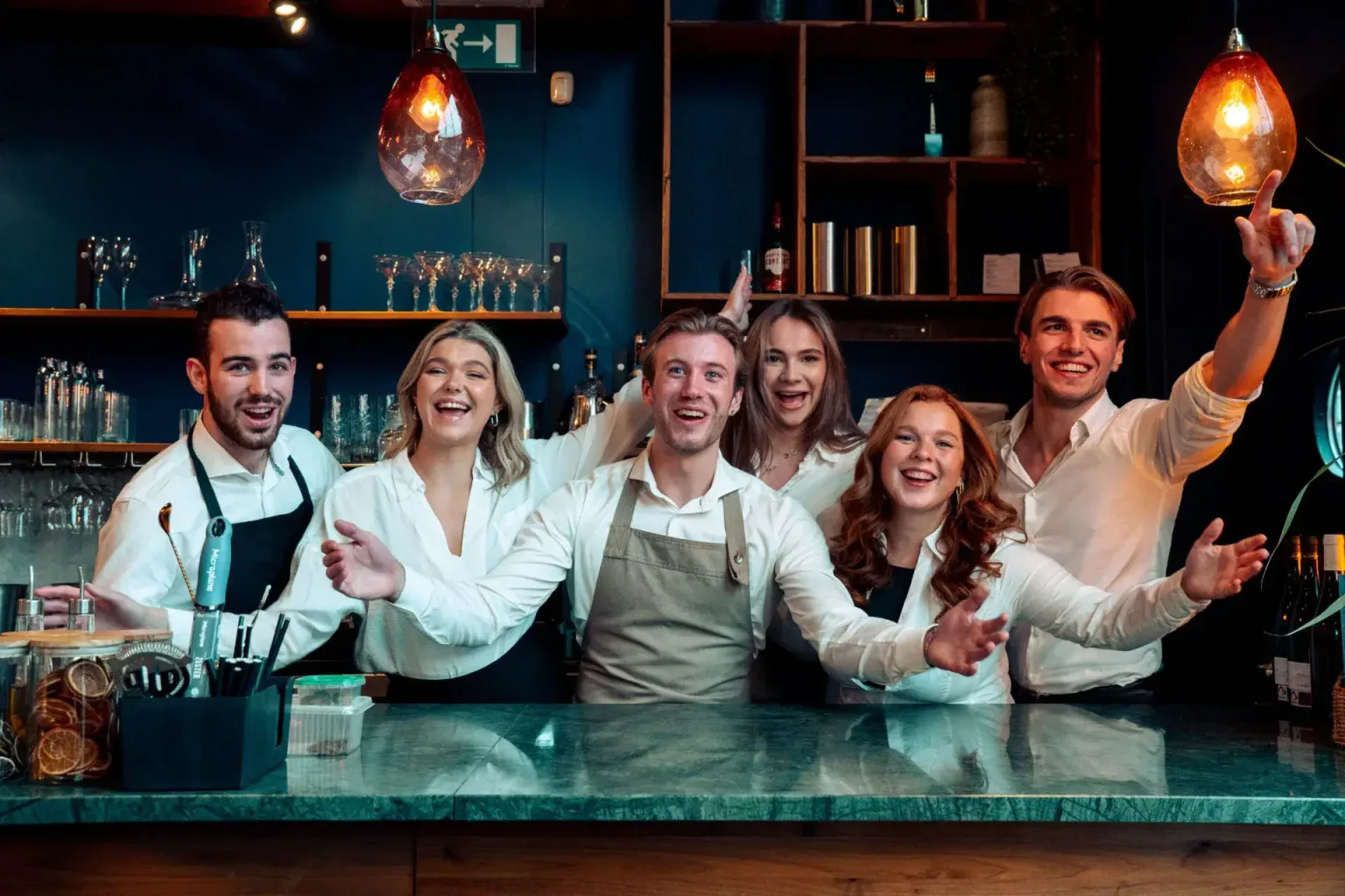 Een stapel euromunten naast een getekend arbeidscontract en een rekenmachine op een houten tafel in een restaurant.